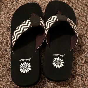 Brown and white Chevron yellow box flip flops.